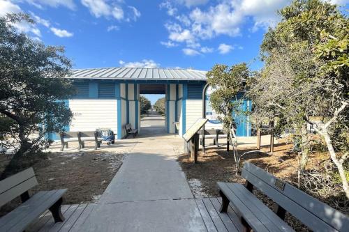 a blue building with benches in front of it at Grayling Beach House in Inlet Beach