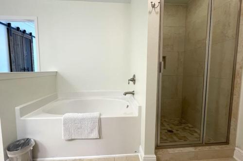 a white bathroom with a shower and a tub at Grayling Beach House in Inlet Beach