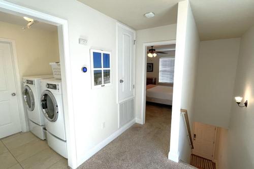 a white laundry room with a washer and dryer at Grayling Beach House in Inlet Beach