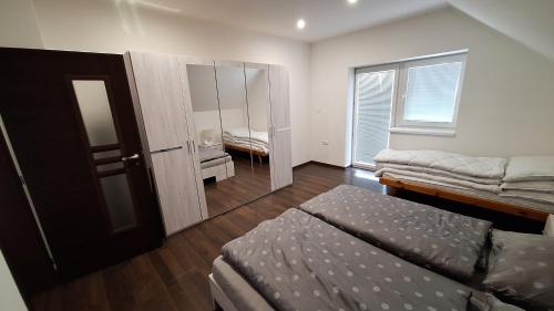 1 dormitorio con cama, espejo y ventana en Penzion Mivex, en Kráľová Lehota
