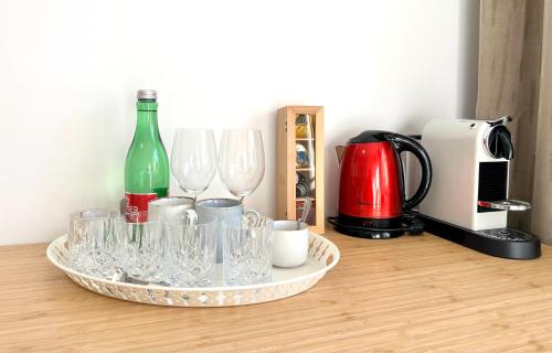 un vassoio di bicchieri da vino e una bottiglia sul tavolo di MIRABELLE Homes a Salisburgo