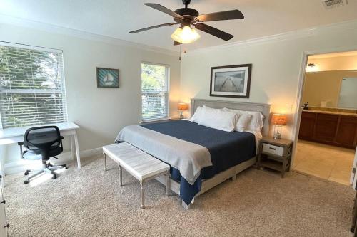 a bedroom with a bed and a desk and a ceiling fan at Grayling Beach House in Inlet Beach