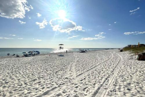 a beach with tracks in the sand and the ocean at Grayling Beach House in Inlet Beach