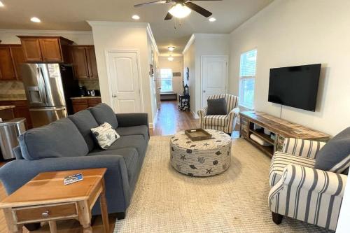 a living room with a couch and a tv at Grayling Beach House in Inlet Beach