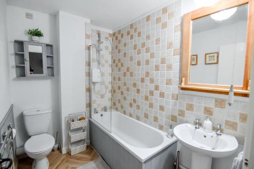 a bathroom with a tub and a toilet and a sink at Charming Malvern Cottage with Outstanding Views in Malvern Wells