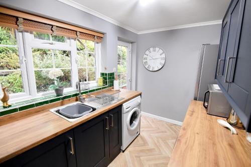 a kitchen with a sink and a washing machine at Charming Malvern Cottage with Outstanding Views in Malvern Wells