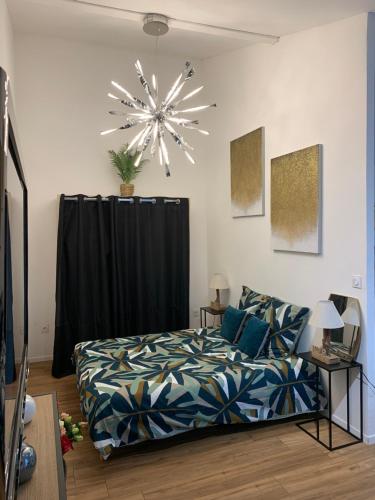 une chambre avec un lit et un lustre dans l'établissement My Little Home, à Varennes-le-Grand