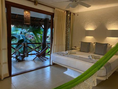 a bedroom with a hammock in front of a sliding glass door at Hotel Para Ti - Adults Only in Holbox Island