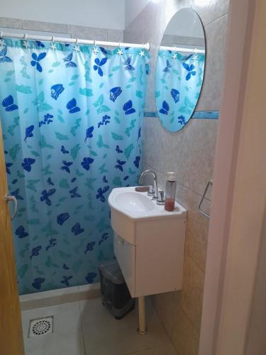 baño con cortina de ducha azul y lavamanos en La Bolsa en 