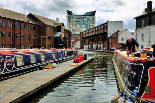 a canal with boats in a city with buildings at Luxury Studio Apartment The Cube Birmingham City Centre in Birmingham