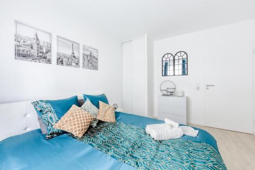 - un lit bleu avec des oreillers dans l'établissement Superbe T2 proche Paris métro 7 à 5 mn à pied, à Ivry-sur-Seine