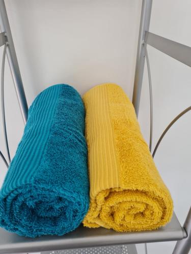 two towels are sitting on a metal chair at Le st jean 1 in Saint-Jean-de-la-Porte