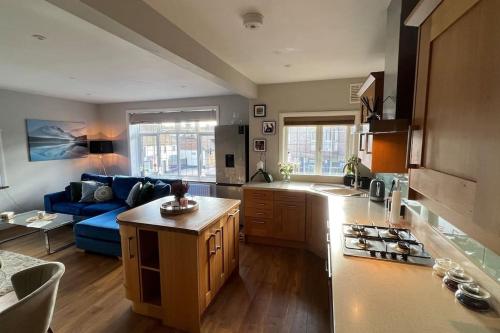 a kitchen and living room with a blue couch at Cosy Corner in Midhurst