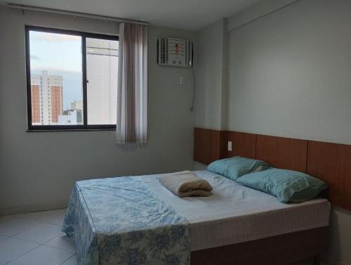 Bett in einem Schlafzimmer mit Fenster in der Unterkunft flats aconchegantes piscina e academia via park in Campos dos Goytacazes