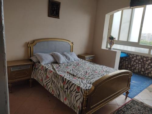 a bedroom with a bed with a zebra print blanket at Elkhaima motel in Giza