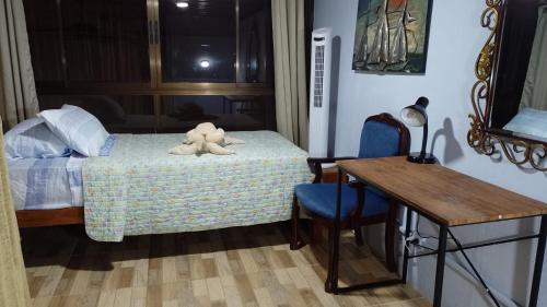 un dormitorio con un osito de peluche sentado en una cama en Natural Pacific Suites, en Manuel Antonio