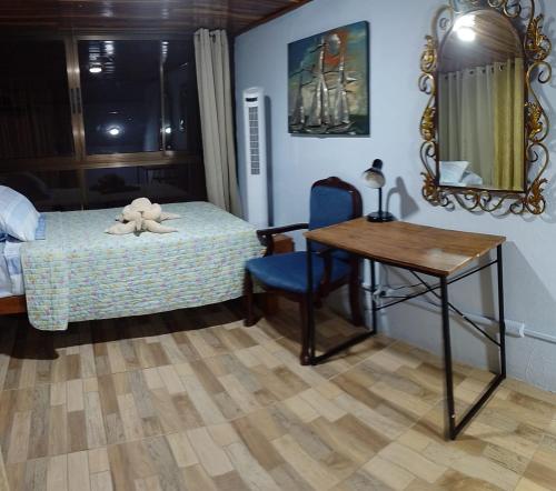 曼努埃爾安東尼奧的住宿－Natural Pacific Suites，一间卧室配有一张床、一张桌子和一面镜子