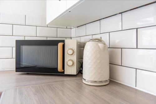 a microwave oven sitting on top of a kitchen floor at South Street Apartments in Derby