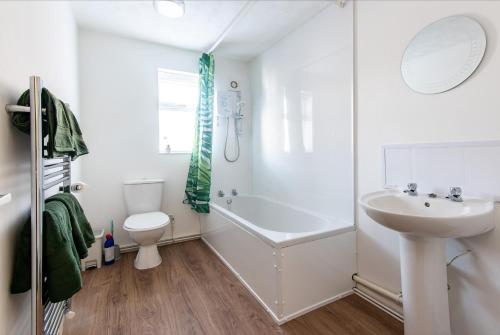 La salle de bains est pourvue d'une baignoire, d'un lavabo et de toilettes. dans l'établissement South Street Apartments, à Derby