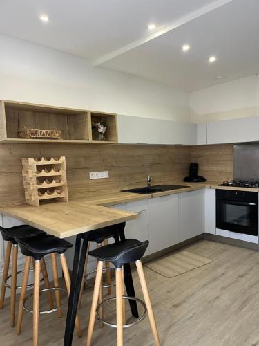 a kitchen with a wooden table and some chairs at Maison Floirac Arkea Arena in Floirac