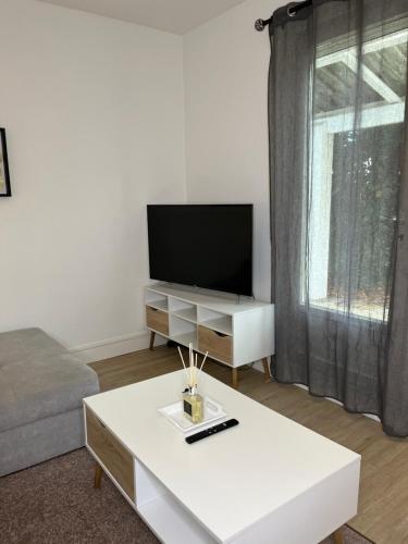 a living room with a tv and a white coffee table at Maison Floirac Arkea Arena in Floirac