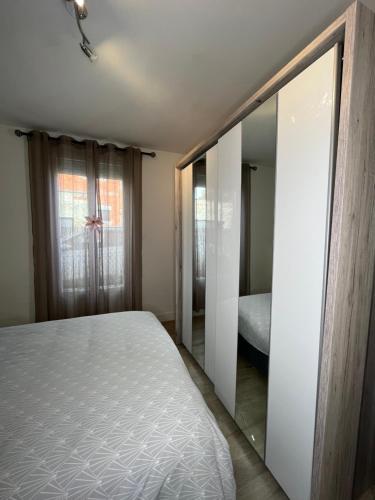 um quarto com uma cama e um espelho em Maison Floirac Arkea Arena em Floirac