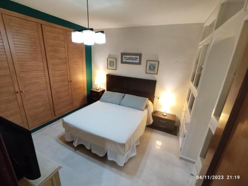 a bedroom with a white bed and two lamps at Viña Home in Torre del Mar