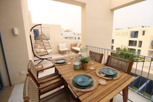 a wooden table with blue plates on a balcony at Casas do Forte Wood 6pax Piscina Privativa by Portugal Hideaway in Tavira