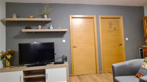 a living room with a television and a wooden door at CASA Campelo - Playas de Pinténs - HIO - Ría de Aldán - CANGAS in Hio