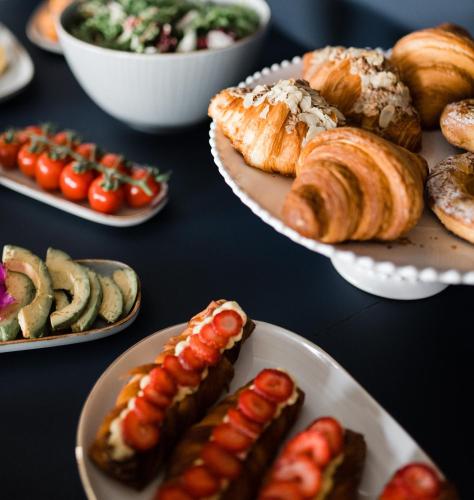 a table topped with plates of hot dogs and pastries at Boutique Hotel HOH in Zagreb