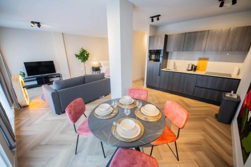 een eetkamer en een woonkamer met een tafel en stoelen bij Alphabet Studio serviced apartments -KS71- in Hilversum