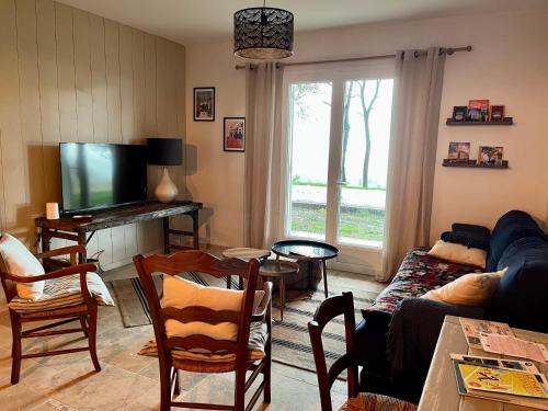 sala de estar con sofá y TV en Maison au Jude en Lamothe-Landerron