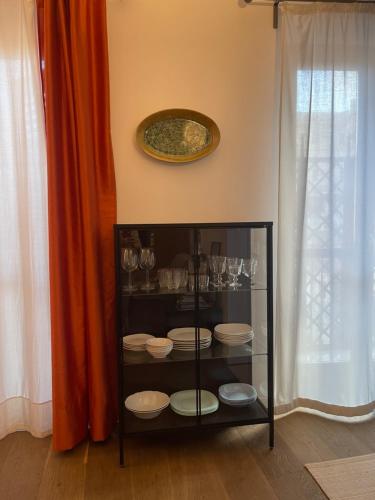 d'une armoire en verre avec des assiettes et des verres dans l'établissement La Loggia dei Re, à Palerme