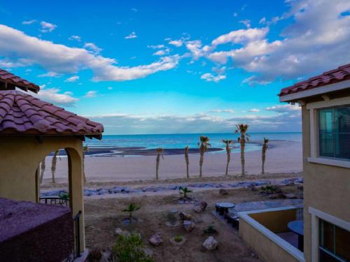 a view of a beach with palm trees and the ocean at El Dorado Ranch San Felipe Beach Condo 73-3 in La Ponderosa