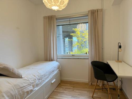 a bedroom with a bed and a desk and a window at Apartment with amazing view in Stockholm