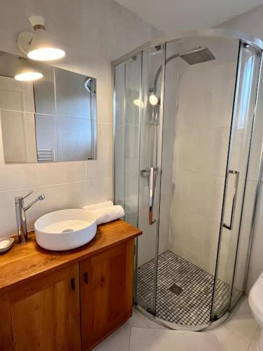 une salle de bain avec une douche en verre et un lavabo dans l'établissement Chalet Cosy, à Lège-Cap-Ferret