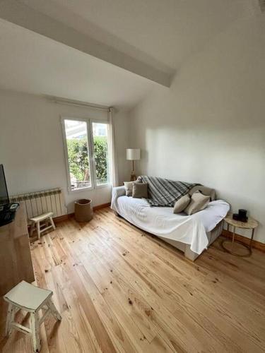 une chambre blanche avec un lit et une fenêtre dans l'établissement Chalet Cosy, à Lège-Cap-Ferret