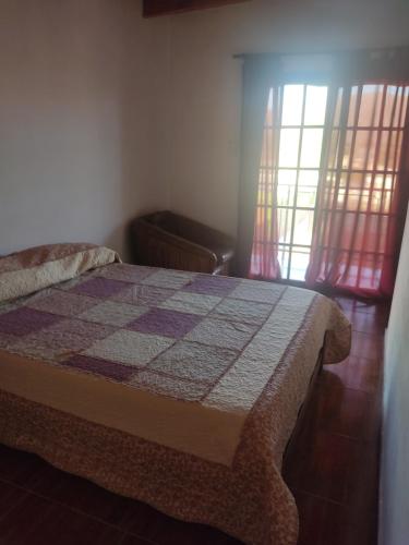 een slaapkamer met een bed en een raam met gordijnen bij Cabañas Los Materos in Santa María