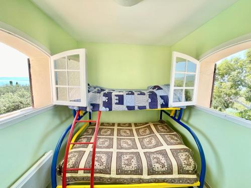 Ce lit superposé se trouve dans un dortoir doté de 2 fenêtres. dans l'établissement Charming French Riviera Villa // Pool, SeaView, AC, 9PAX //, à Saint-Raphaël