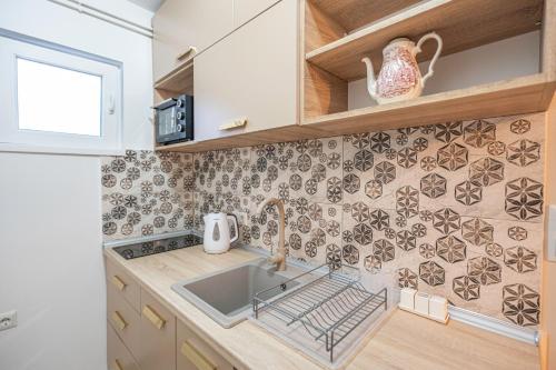a kitchen with a sink and a counter at Calendula apartments in Tuzla