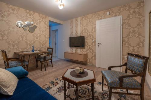 a living room with a blue couch and a table at Calendula apartments in Tuzla