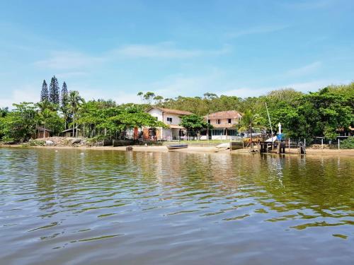 a house on the shore of a body of water at LINDO SOBRADO COM 7 QUARTOS NA BARRA DO ITAPOCU in Paraty