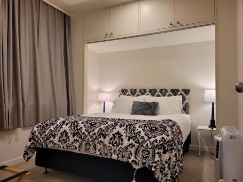 a bedroom with a bed with a black and white blanket at Wellington Central, 2bedroom Suite in Wellington