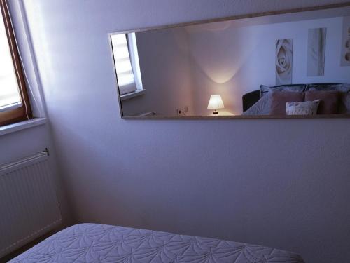 a bedroom with a mirror and a bed and a lamp at Apartman 053 in Doboj