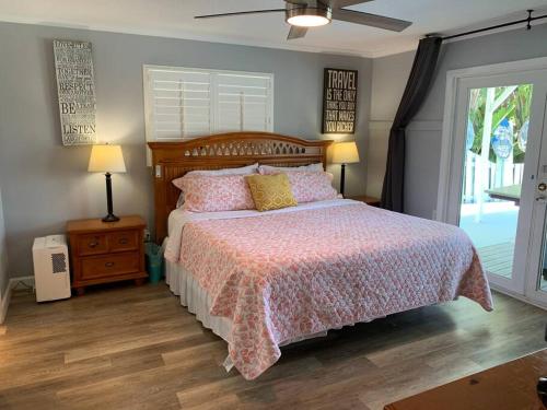 a bedroom with a bed with a pink comforter at Oceanview home on Indian Rocks Beach in Clearwater Beach