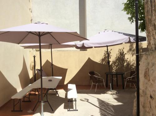 un patio con sombrillas, sillas y mesas en Da Sciuri case vacanza Barisciano, en Barisciano