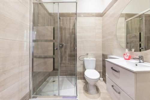 a bathroom with a shower and a toilet and a sink at 70s Hostel in Kraków