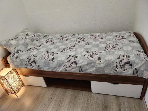 a bed with a quilt on it with a lamp at Ferienhaus Susanne in Heinsberg