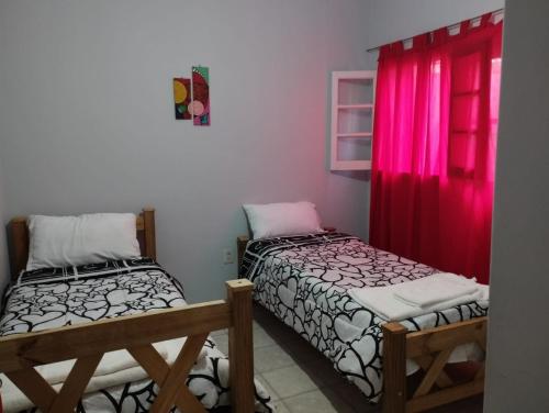 2 camas en una habitación con ventana roja en HOSTAL HOUSE REYMON,habitaciones privadas" precio por persona" en Mendoza