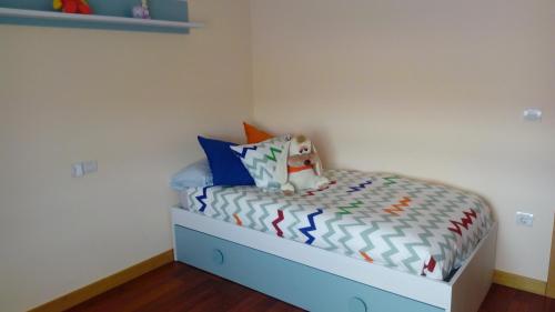 um pequeno quarto com uma cama azul e branca em Casa Chocolate San Miguel del Pino Valladolid em San Miguel del Pino